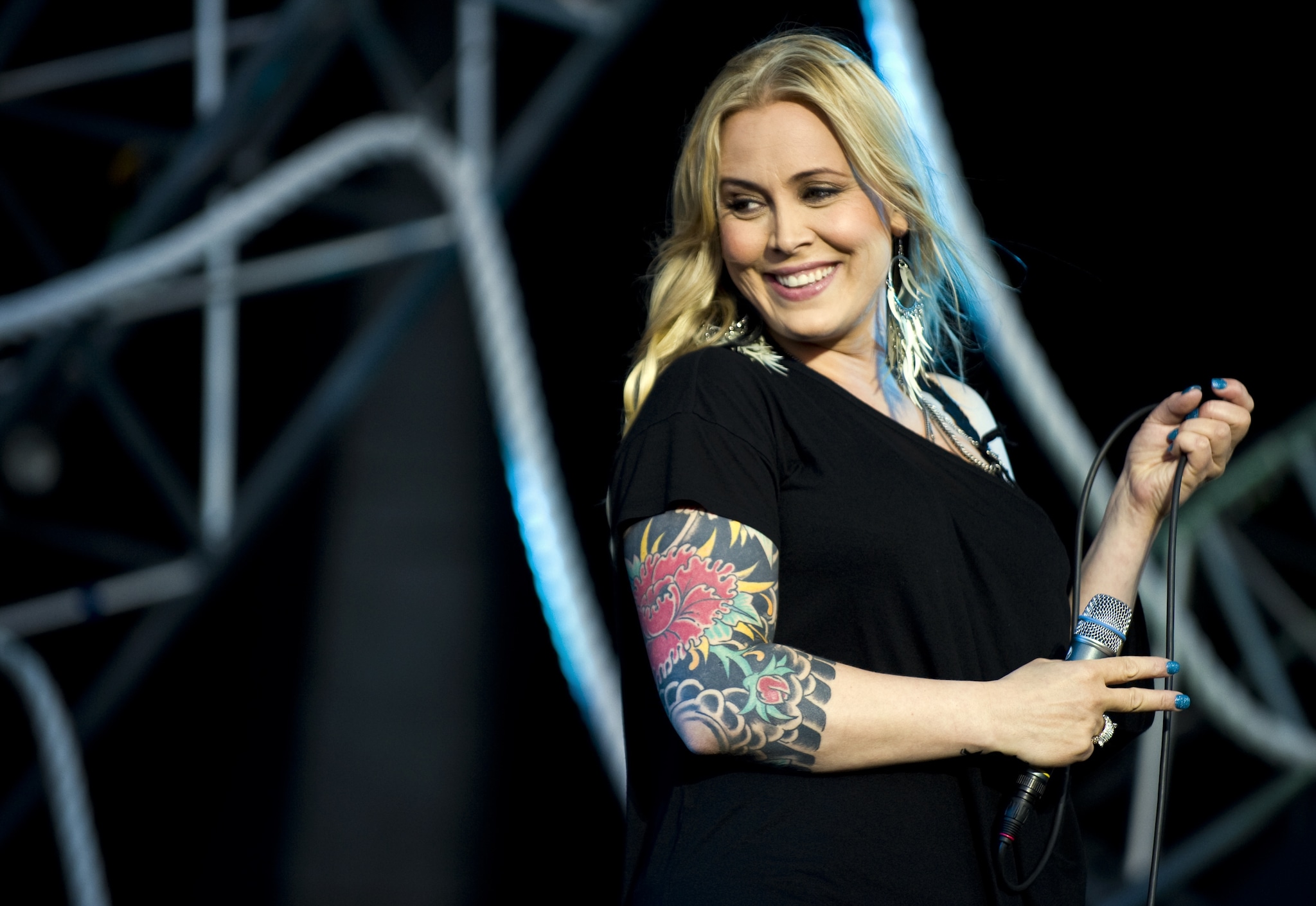 Anouk tattoos: wide tattooed portrait showing the full arm silhouette, the shoulder placement and the contrast between ink and a light top