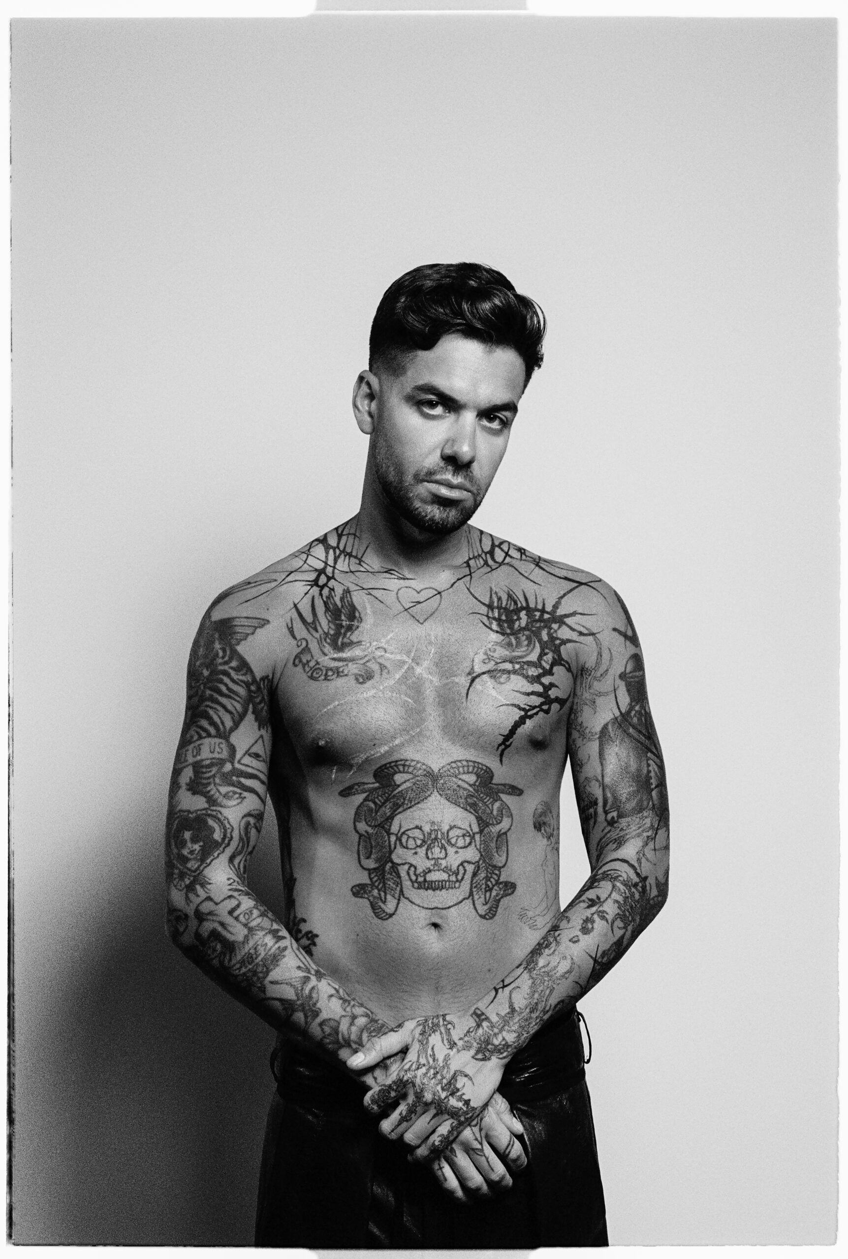 Anyma tattoos: Front-facing tattoo portrait showing the central skull and surrounding chest and arm imagery