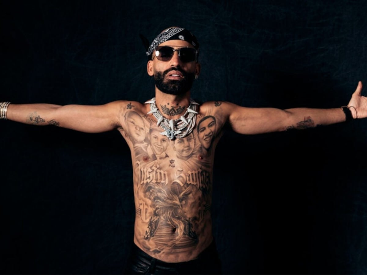 Arcángel tattoos: Tattoo evidence: stage portrait with chest portraits, script and symbols visible.