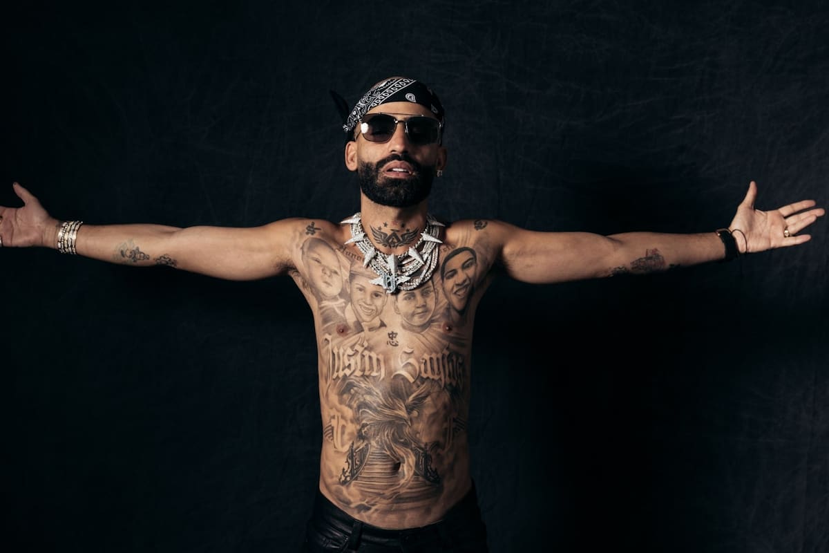 Arcángel tattoos: Tattoo evidence: wide arms-open portrait showing the mural from shoulders to abdomen.