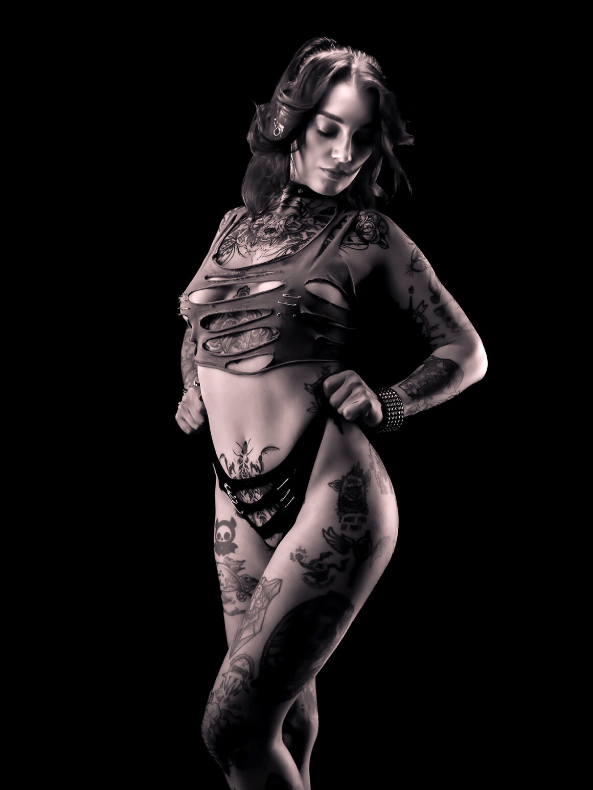 Axelle Fescia tattoos: Show the mixed tattoo collection continuing across the thigh and down the leg.