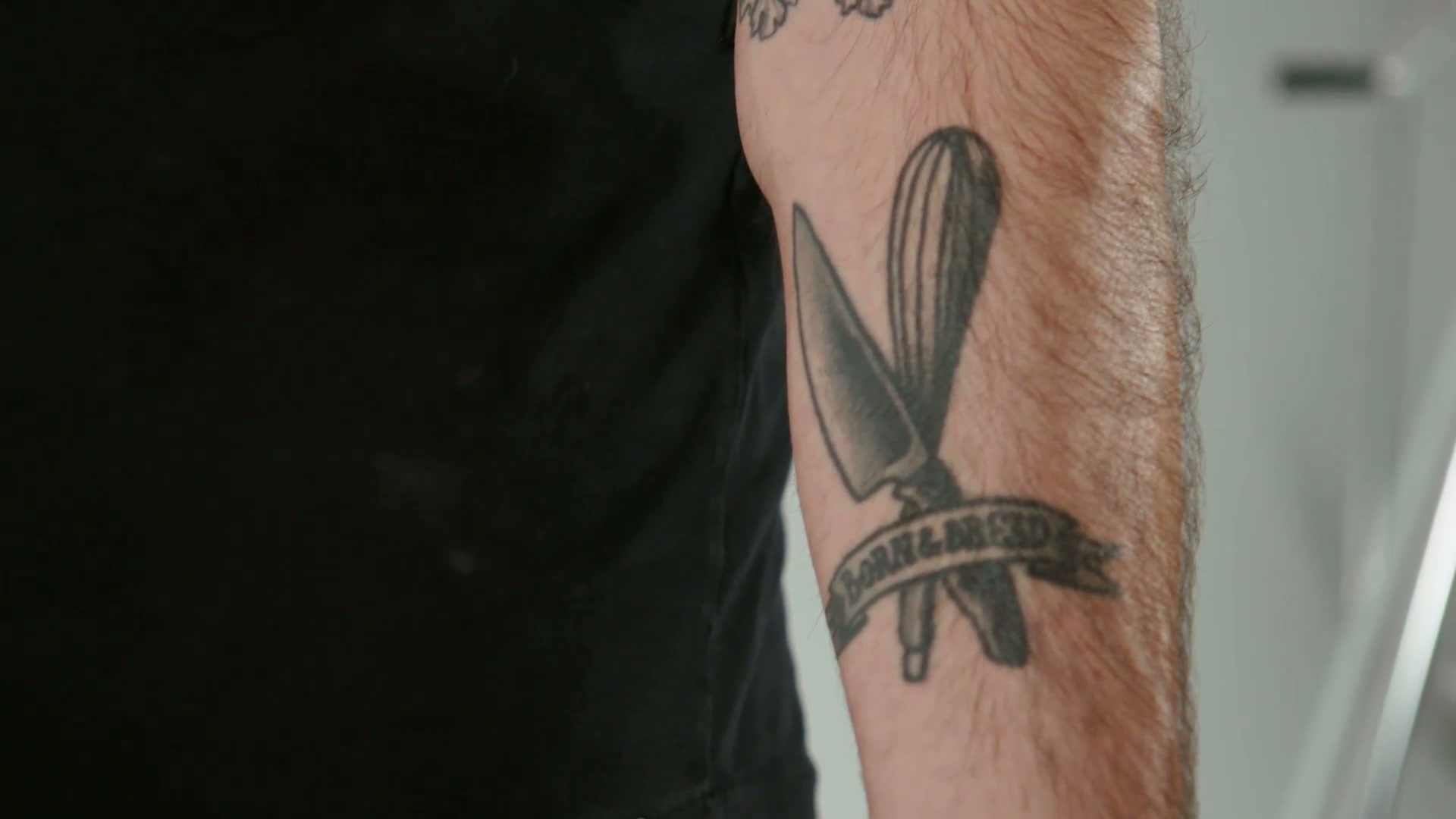 Babish tattoos: close view of the knife, whisk, and BORN & BREAD forearm piece