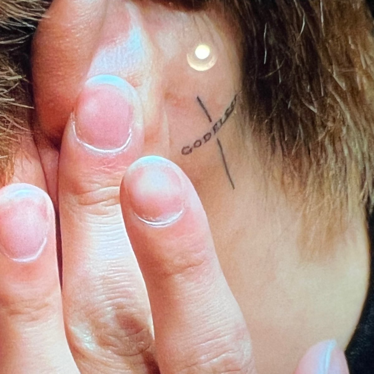 BamBam tattoos: GODBLESS cross behind the ear