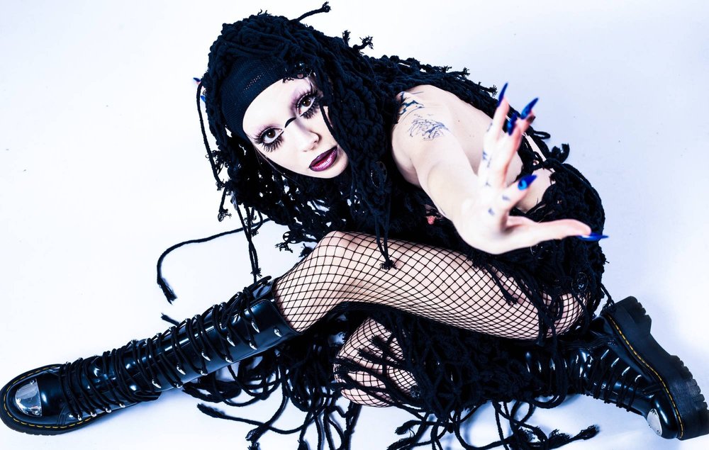 Bambie Thug tattoos: gothic portrait showing hand and upper-arm tattoo details with the full styling
