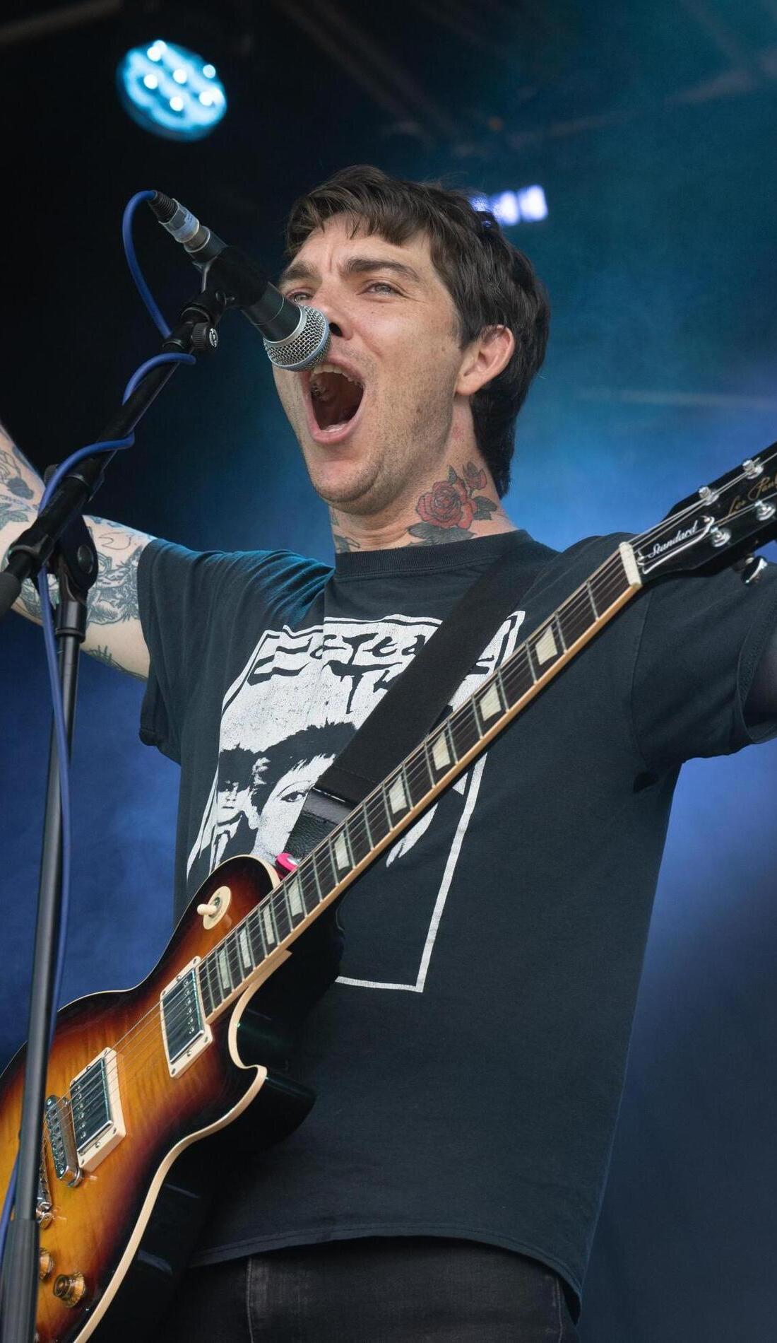 Barry Johnson tattoos: Genuine tattoo photograph showing Barry Johnson performing with neck and arm tattoos clearly visible.
