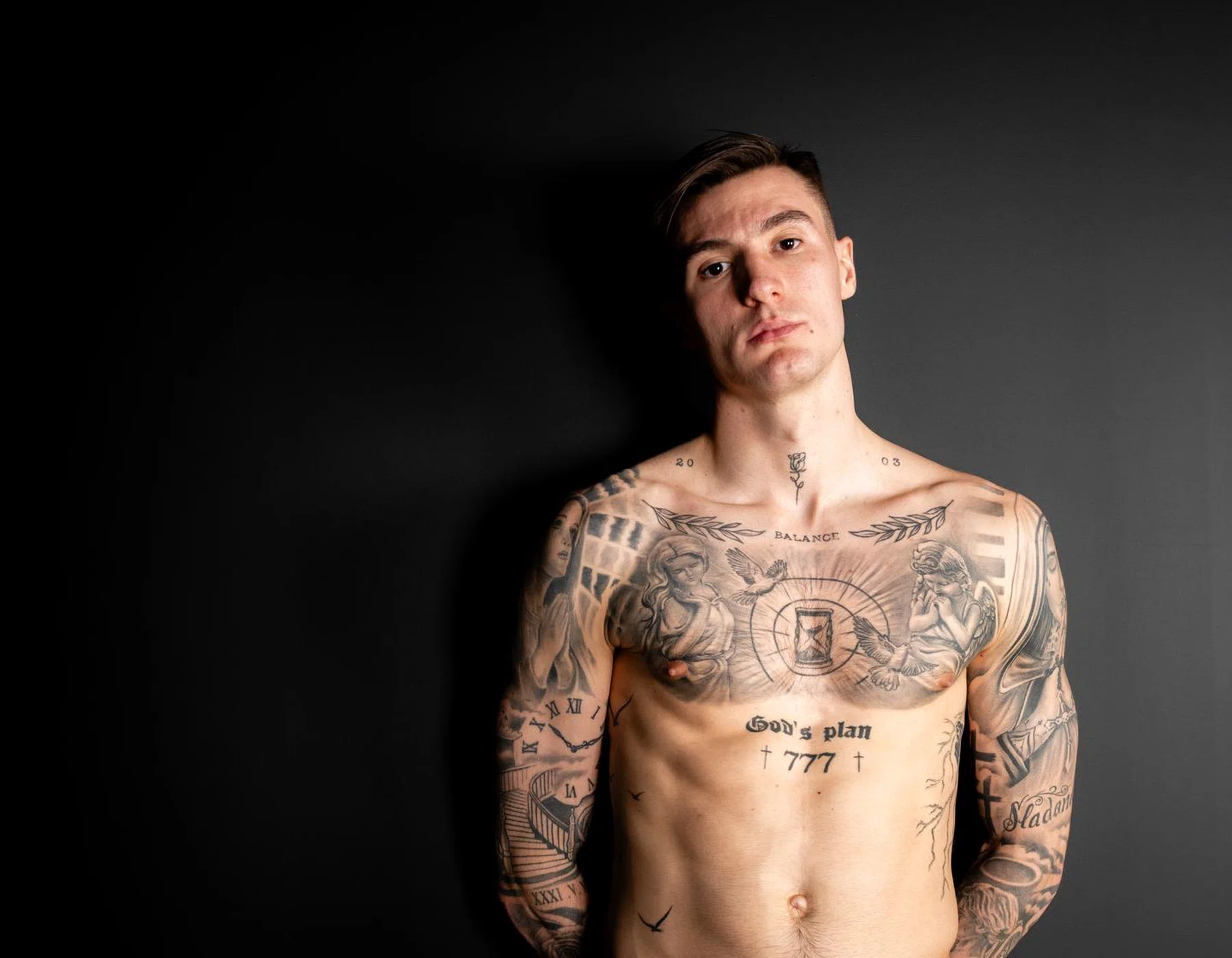 Benjamin Šeško Separate front-facing studio photograph showing the chest lettering and surrounding illustrative work from another angle Benjamin Šeško tattoos: Separate front-facing studio photograph showing the chest lettering and surrounding illustrative work from another angle