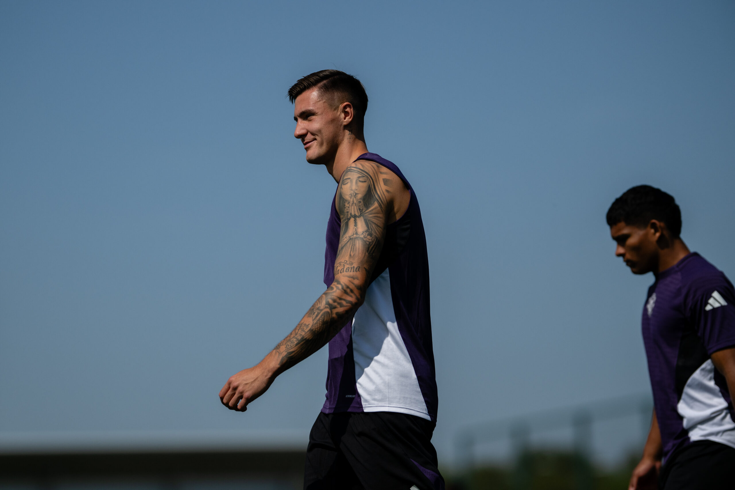 Benjamin Šeško Wide outdoor view of the upper-arm religious portrait and sleeve coverage in a separate training moment Benjamin Šeško tattoos: Wide outdoor view of the upper-arm religious portrait and sleeve coverage in a separate training moment