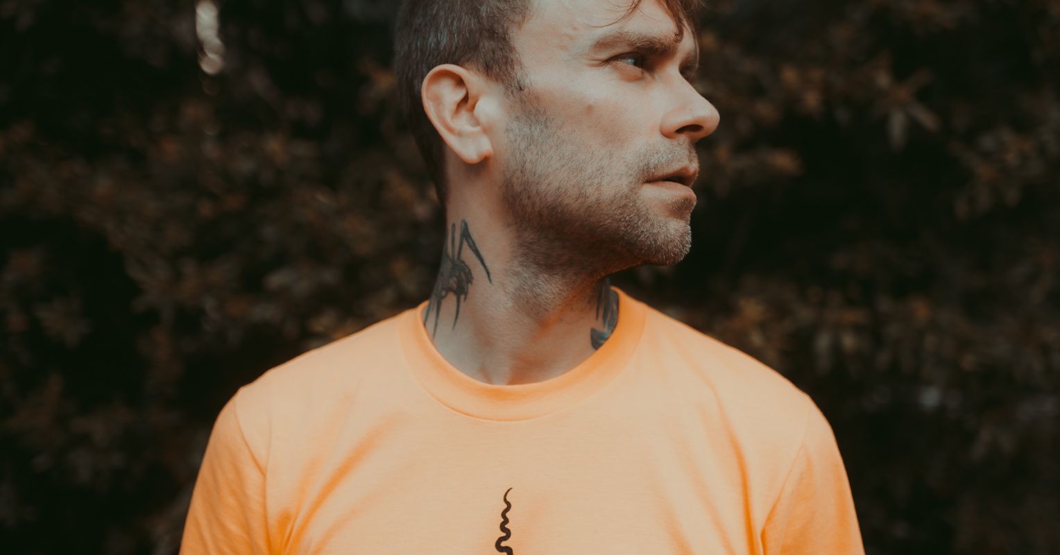 Bert McCracken tattoos: side profile showing the spider-like neck tattoo and central body mark