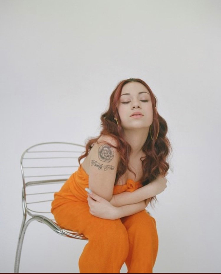 Bhad Bhabie tattoos: studio portrait showing the rose and script combination on the upper arm