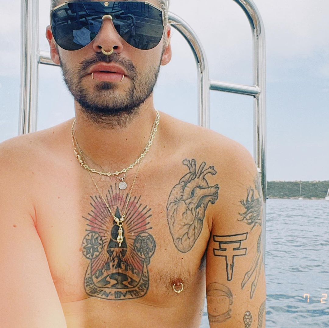 Bill Kaulitz tattoos: sharp color boat portrait with the anatomical heart, large chest emblem, shoulder work and upper-arm ink