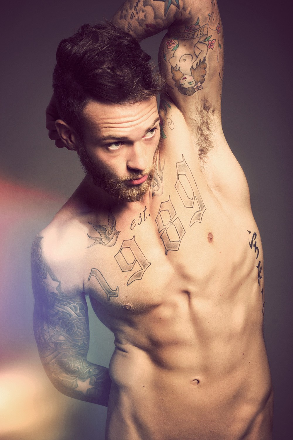 Billy Huxley Illustrated pin-up face, wavy hair, flowers and curved banner on inner upper arm Billy Huxley tattoos: Illustrated pin-up face, wavy hair, flowers and curved banner on inner upper arm