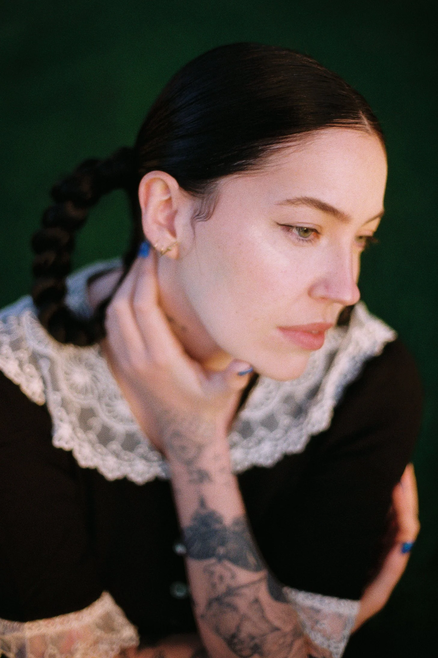Bishop Briggs tattoos: Portrait showing dense black-and-gray forearm work and lettering.