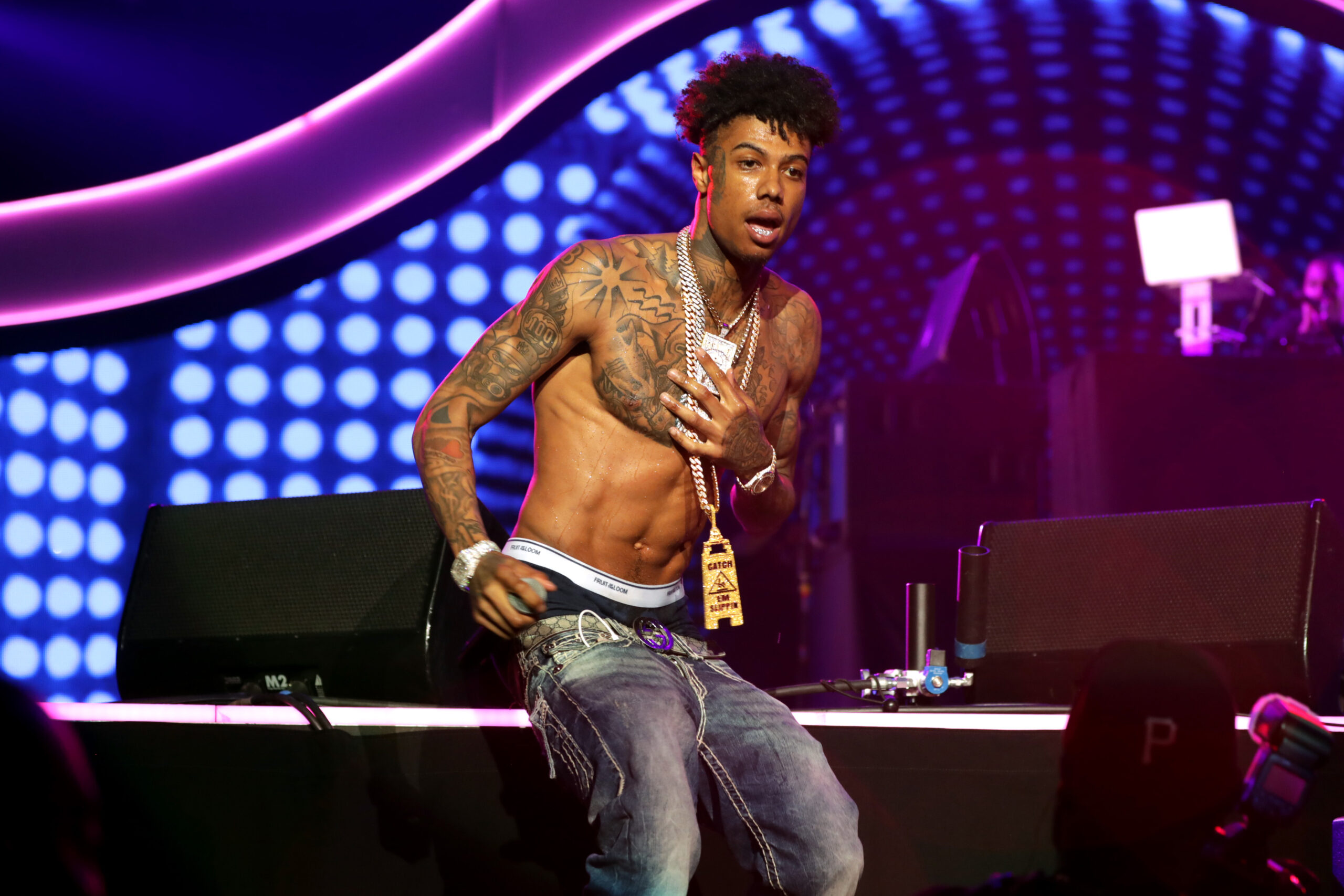 Blueface shirtless with chest and arm tattoos on stage