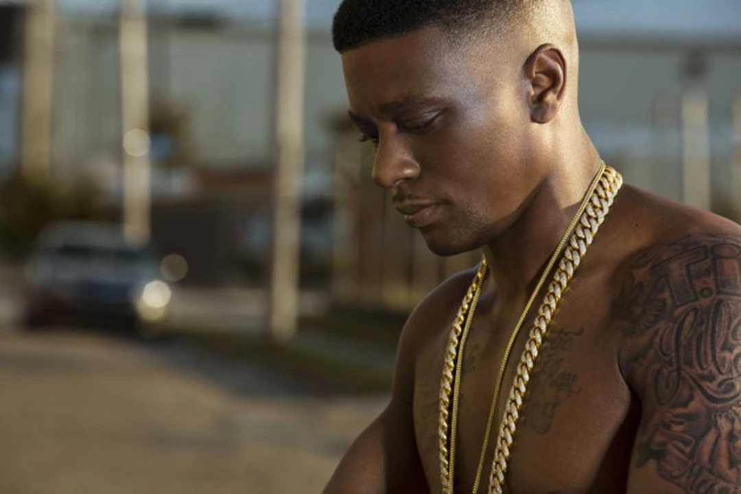 Boosie BadAzz tattoos: side portrait showing the detailed upper-arm sleeve and chest script