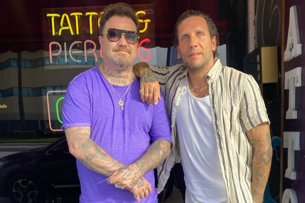 Brandon Novak tattoos: high-quality standing portrait showing hand, forearm and chest tattoo details