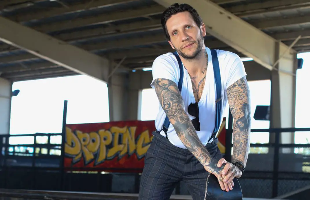 Brandon Novak tattoos: clear full-body view showing layered black-and-gray arm coverage and chest work