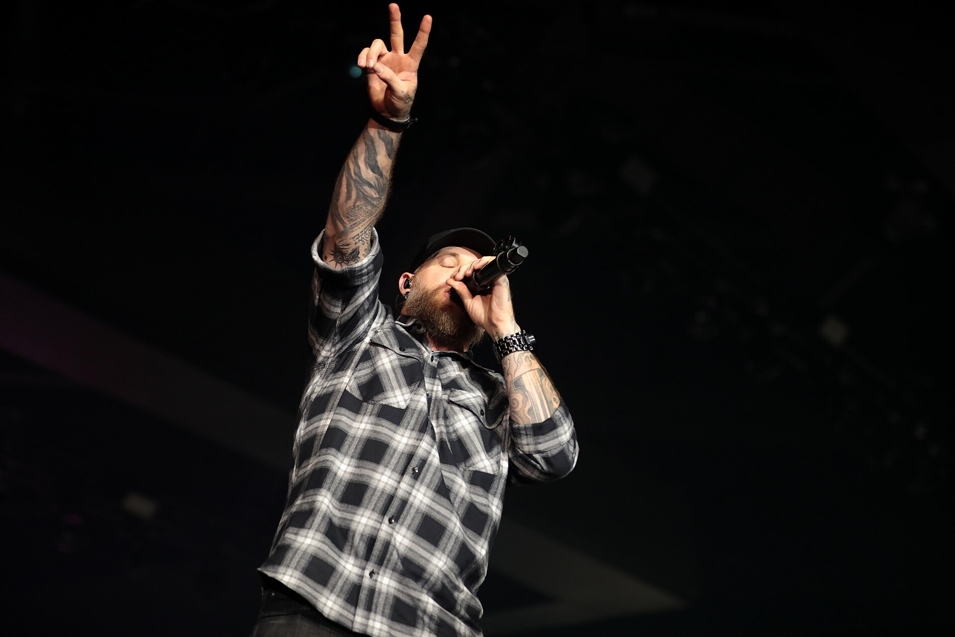 Brantley Gilbert arm tattoos in a clear stage portrait