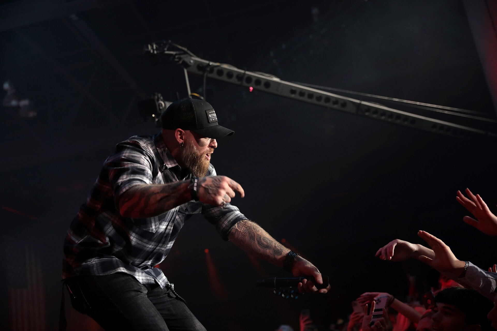 Brantley Gilbert tattooed arm reaching toward the crowd