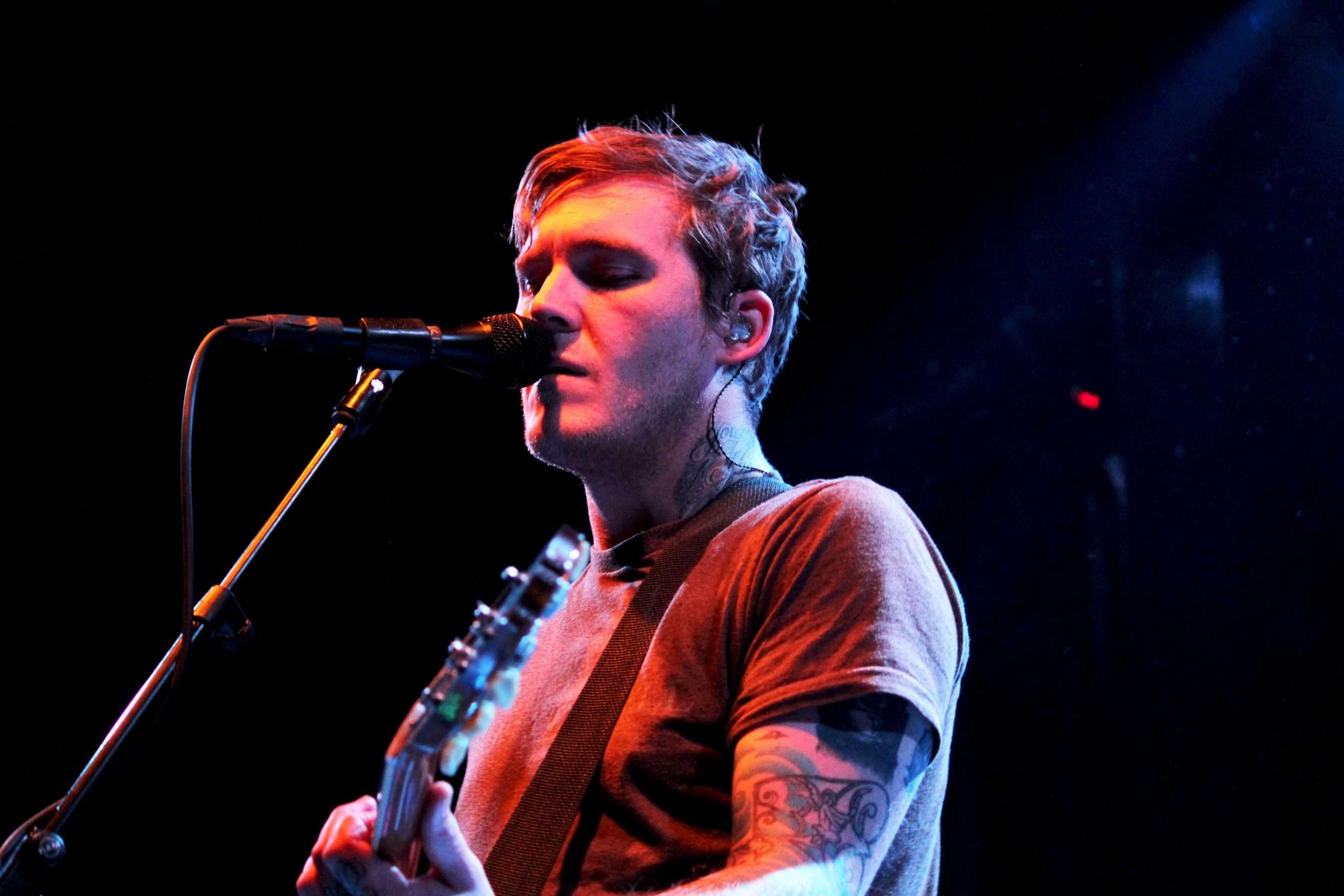 Brian Fallon tattoos: neck and arm tattoos in a live performance photograph