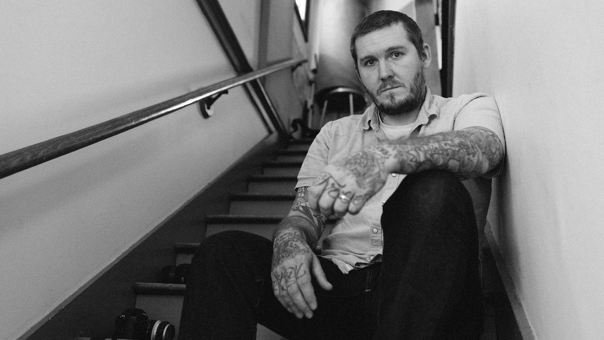 Brian Fallon tattoos: tattooed arms and neck in a concert portrait