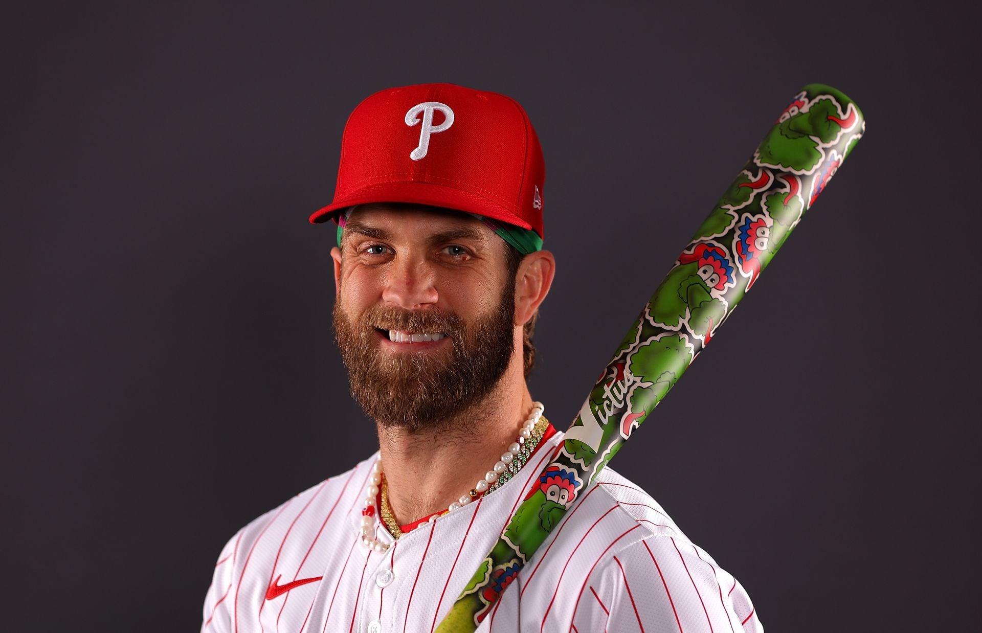 Bryce Harper in a contextual photograph: Harper in a contextual Phillies portrait with Phanatic-themed bat; not tattoo evidence; not tattoo evidence