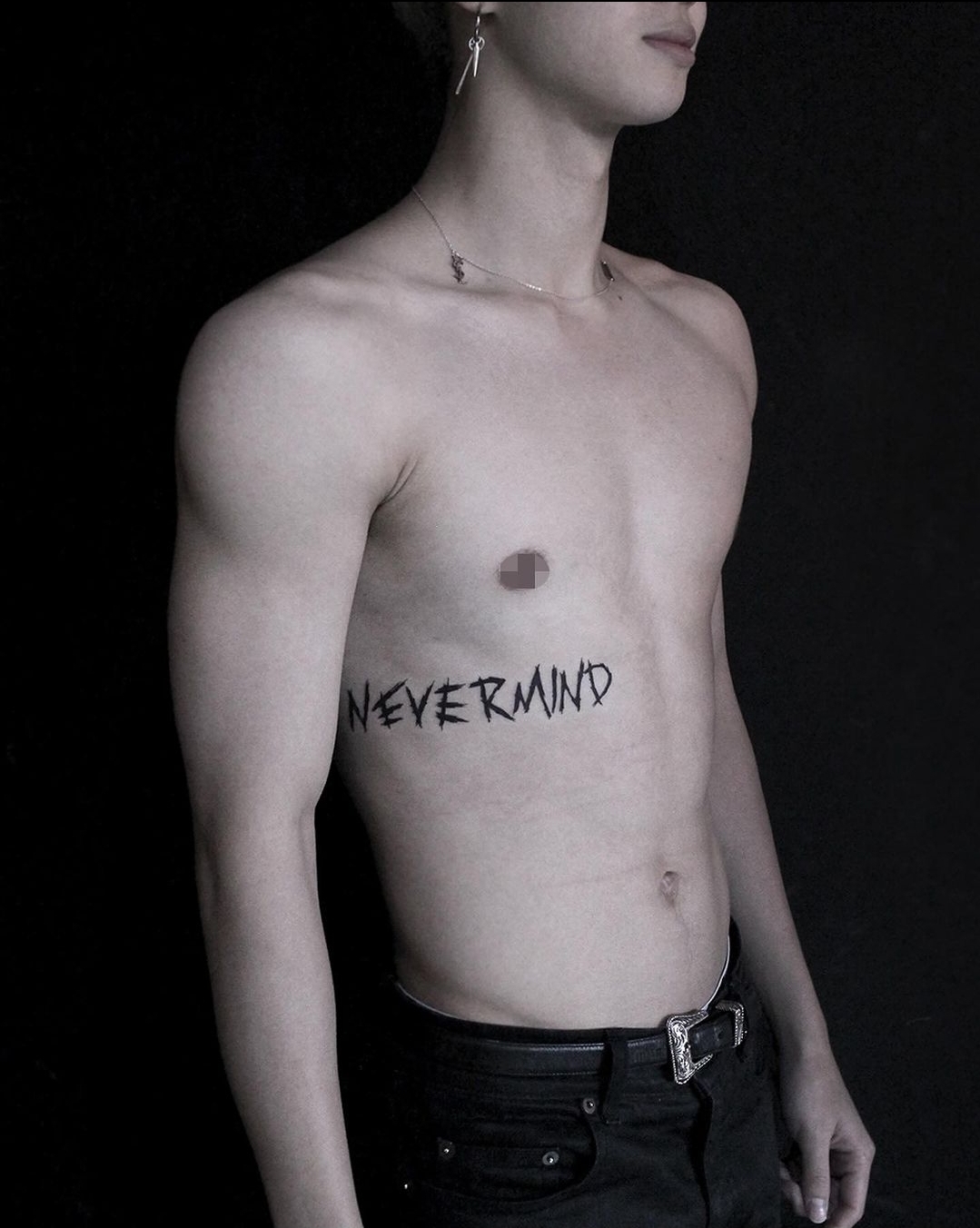 BTS Jimin tattoos: Close photograph documenting the NEVERMIND rib lettering.