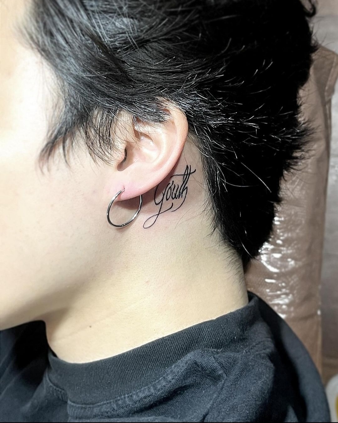 BTS Jimin tattoos: Side-profile photograph documenting the YOUTH ear tattoo.