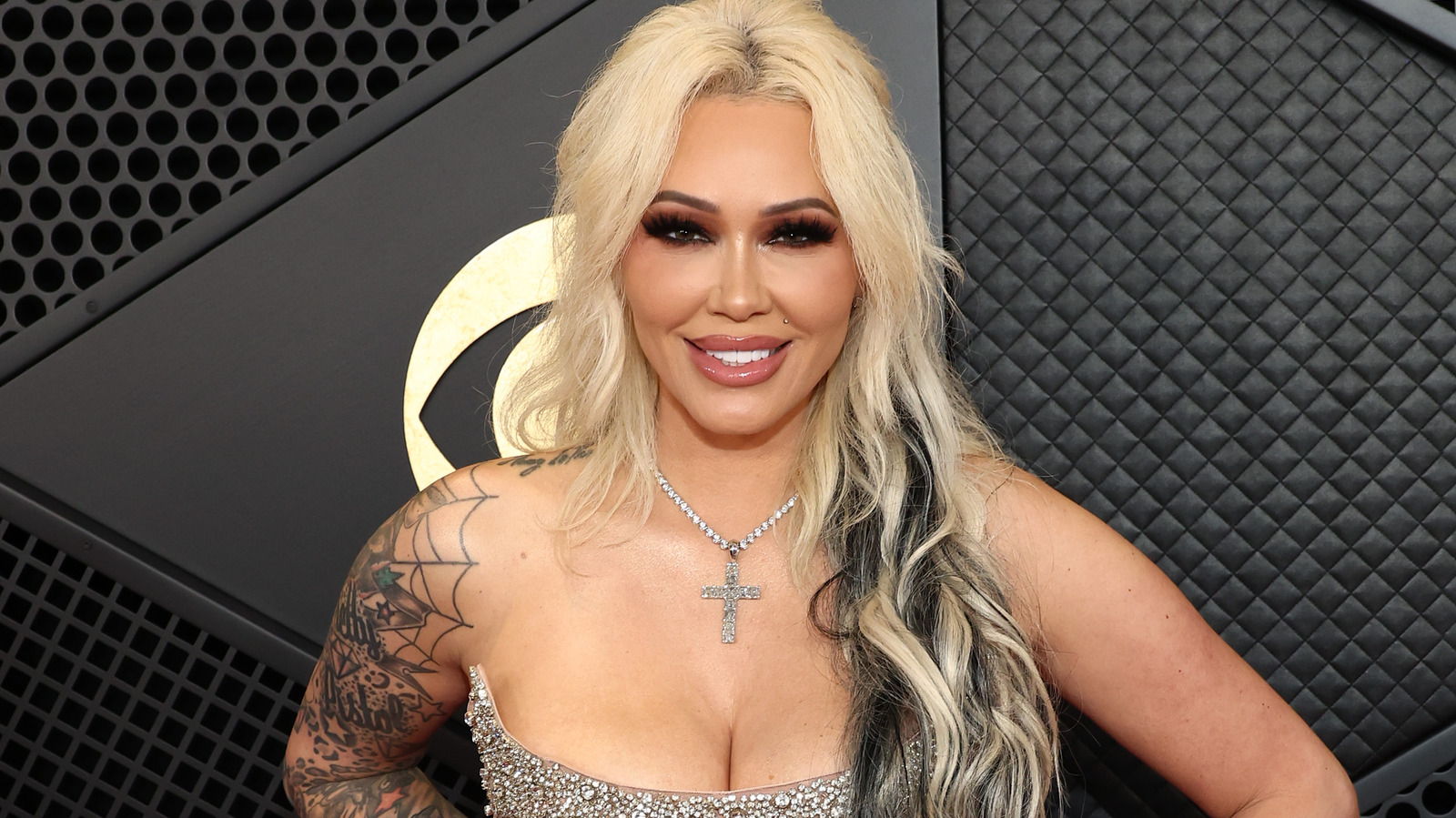 Bunnie XO in a black gown with face and arm tattoos Bunnie XO tattoos: Distinct close portrait showing Bunnie's face and arm sleeve; used as an additional sleeve view, not as proof for a smaller hidden design.