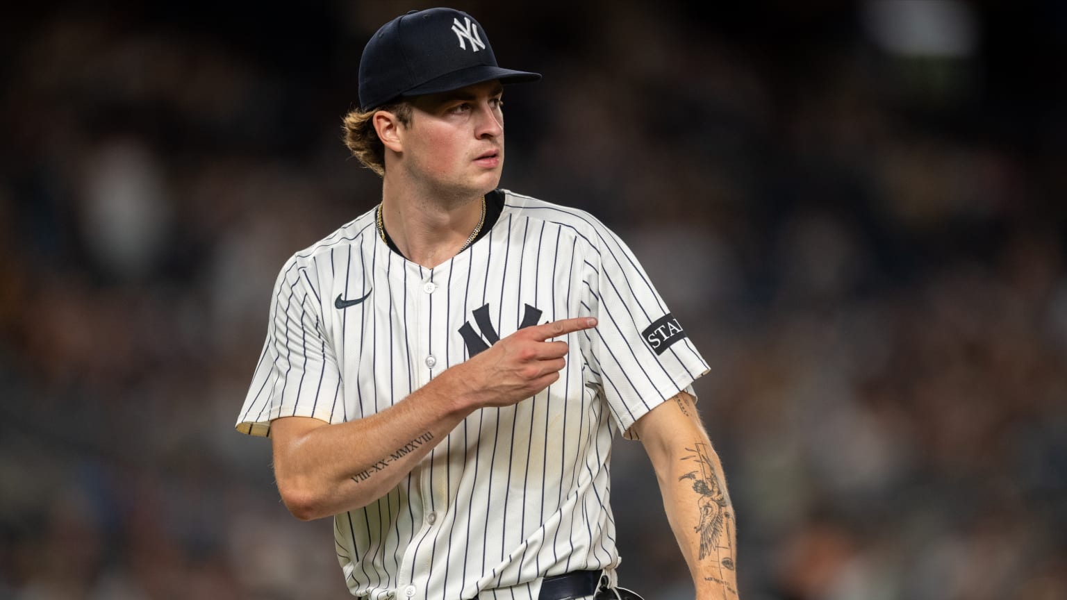 Cam Schlittler tattoos: Tattoo evidence: clear forearm view of Roman numerals and larger sleeve imagery.