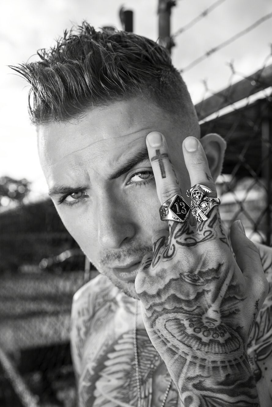 Caskey tattoos: high-resolution close portrait showing face, hand, chest and finger tattoos
