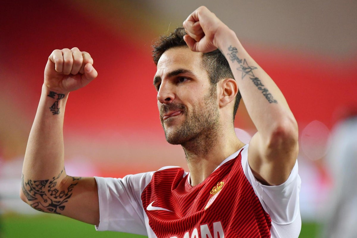 Cesc Fabregas raising both tattooed arms during a football celebration