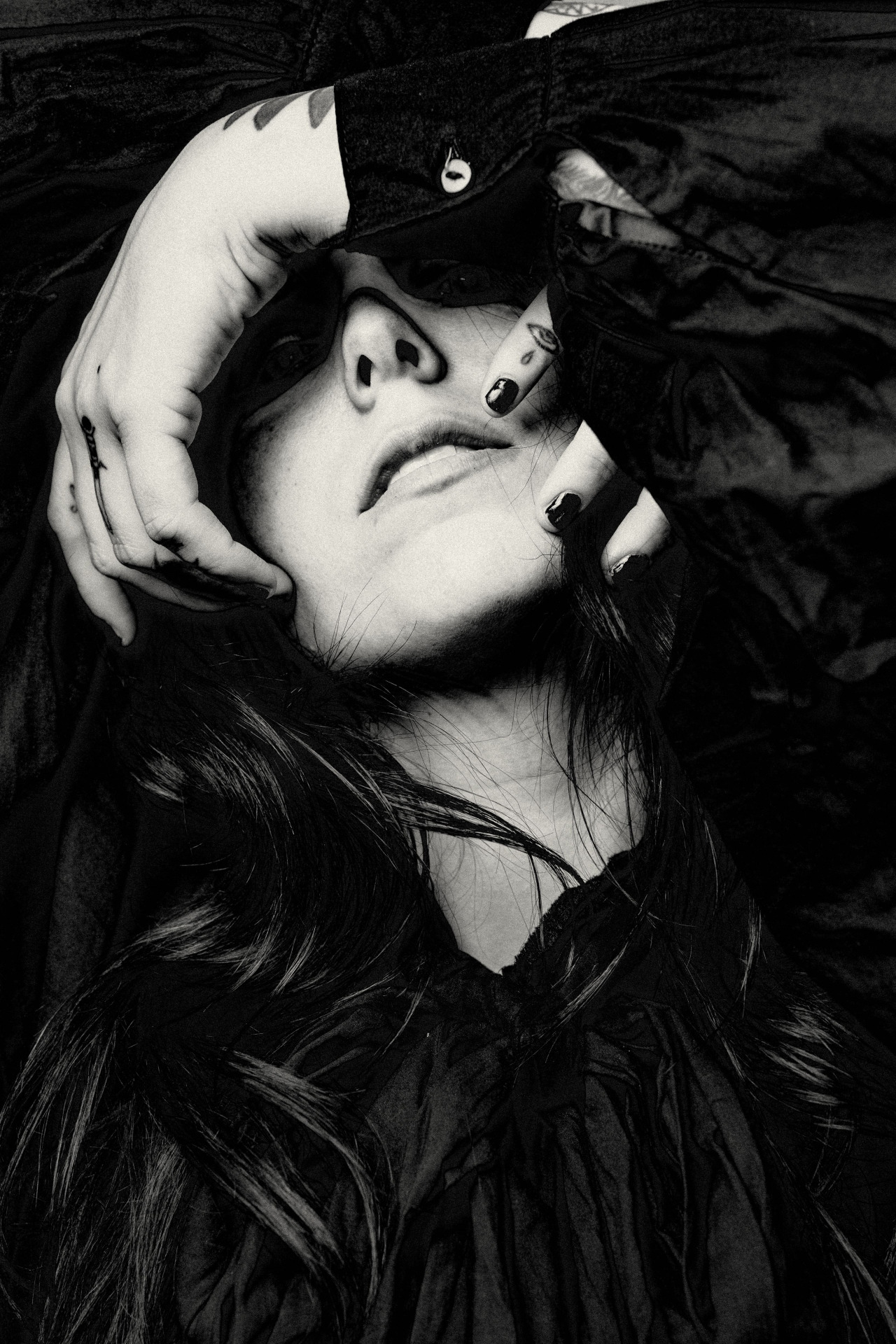 Chelsea Wolfe tattoos: a tight black-and-white portrait where finger tattoos frame the face