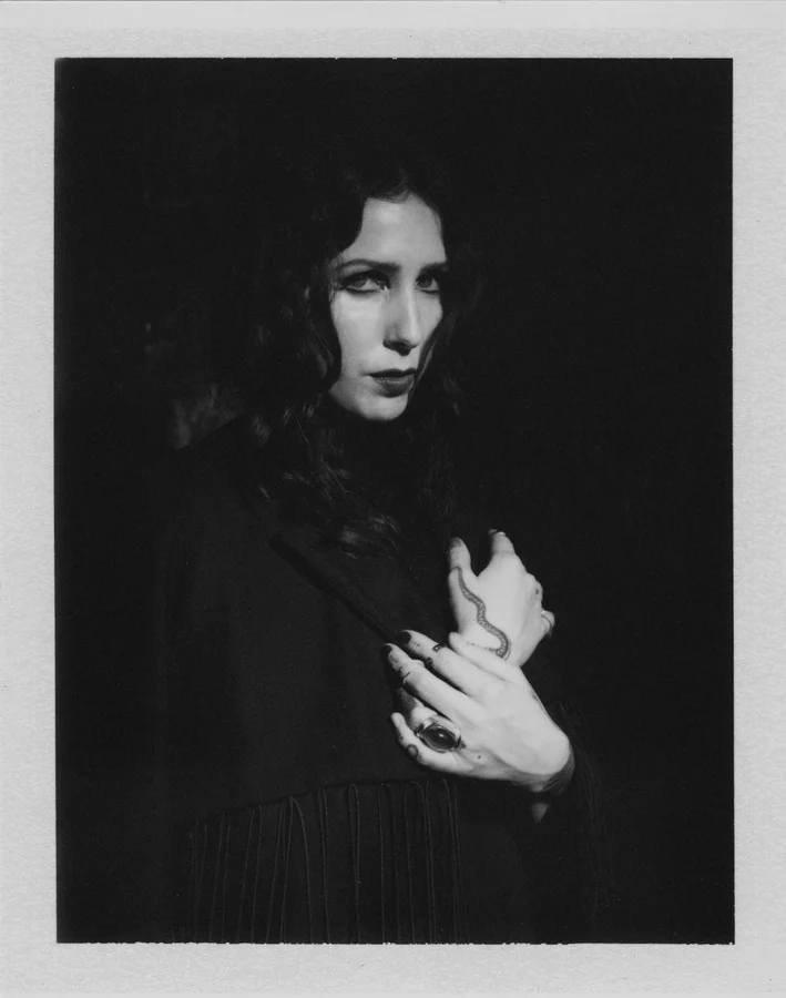 Chelsea Wolfe tattoos: a close hand and finger view with a snake line and smaller symbols