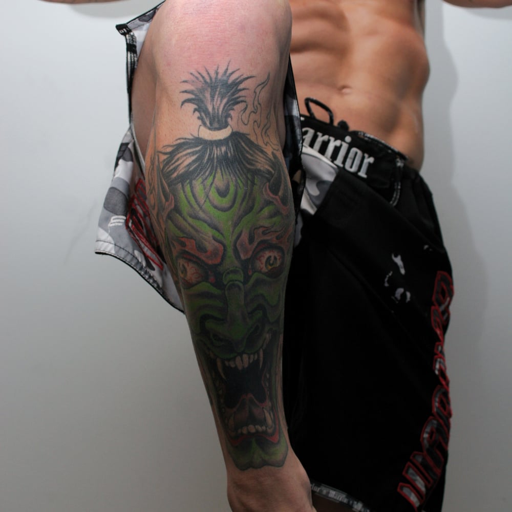 Chris Leben tattoos: The green mask-like face on his forearm