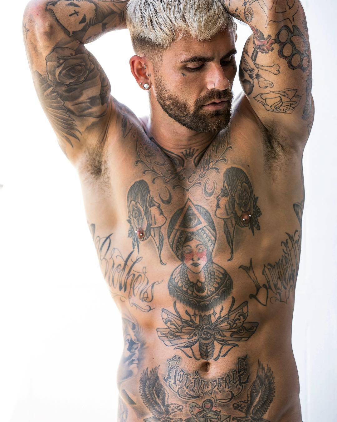Chris Perceval tattoos: Symmetrical moth-like winged insect containing an eye, placed above Chris Perceval’s navel