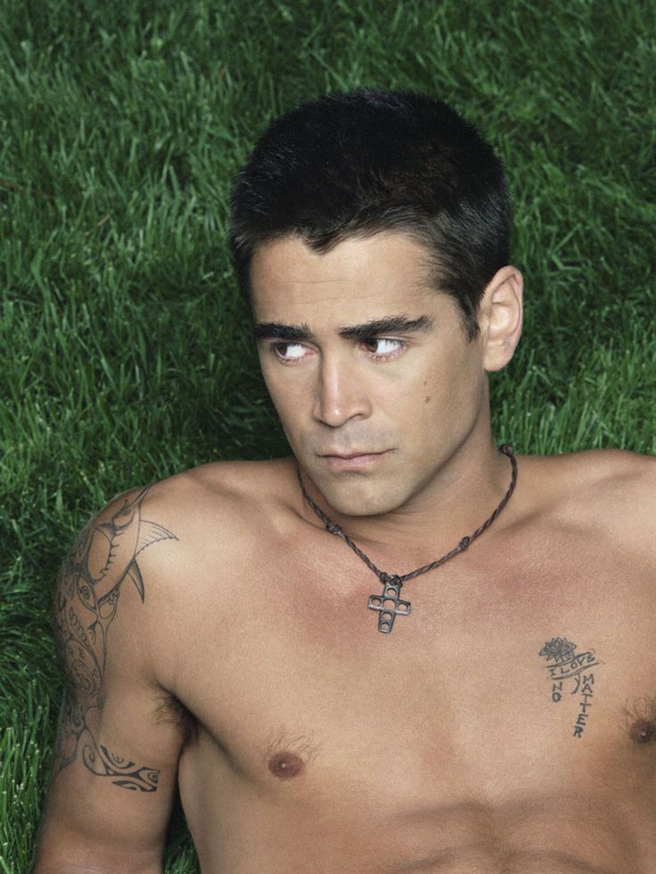 Colin Farrell shirtless with his arm and chest tattoos visible