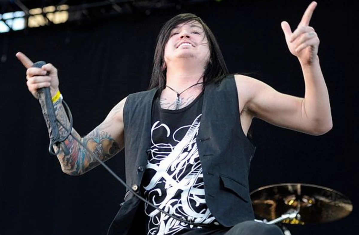 Craig Mabbitt tattoos: wide high-resolution performance photograph showing the tattooed upper arms and chest