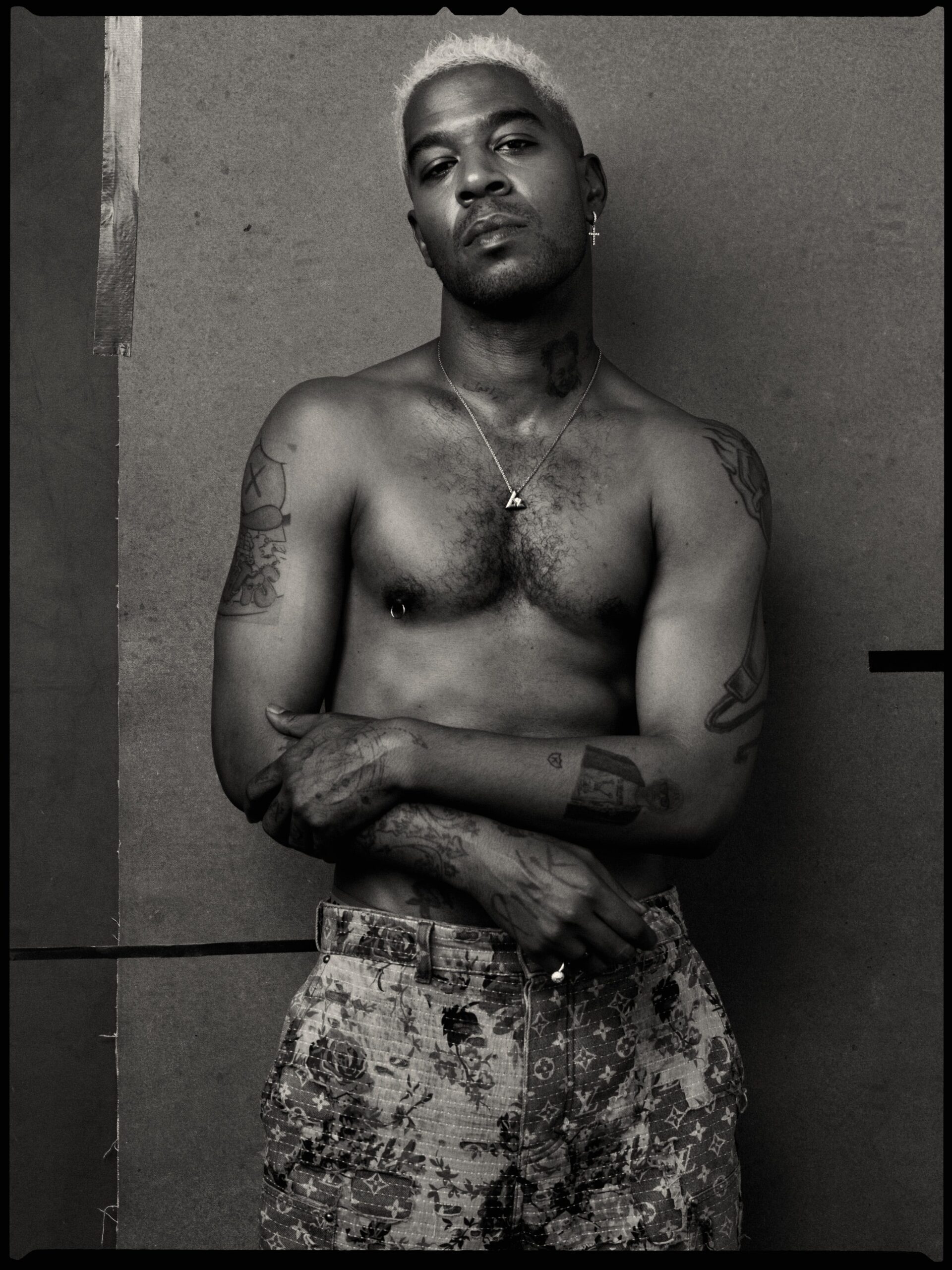 Kid Cudi shirtless showing arm and neck tattoos