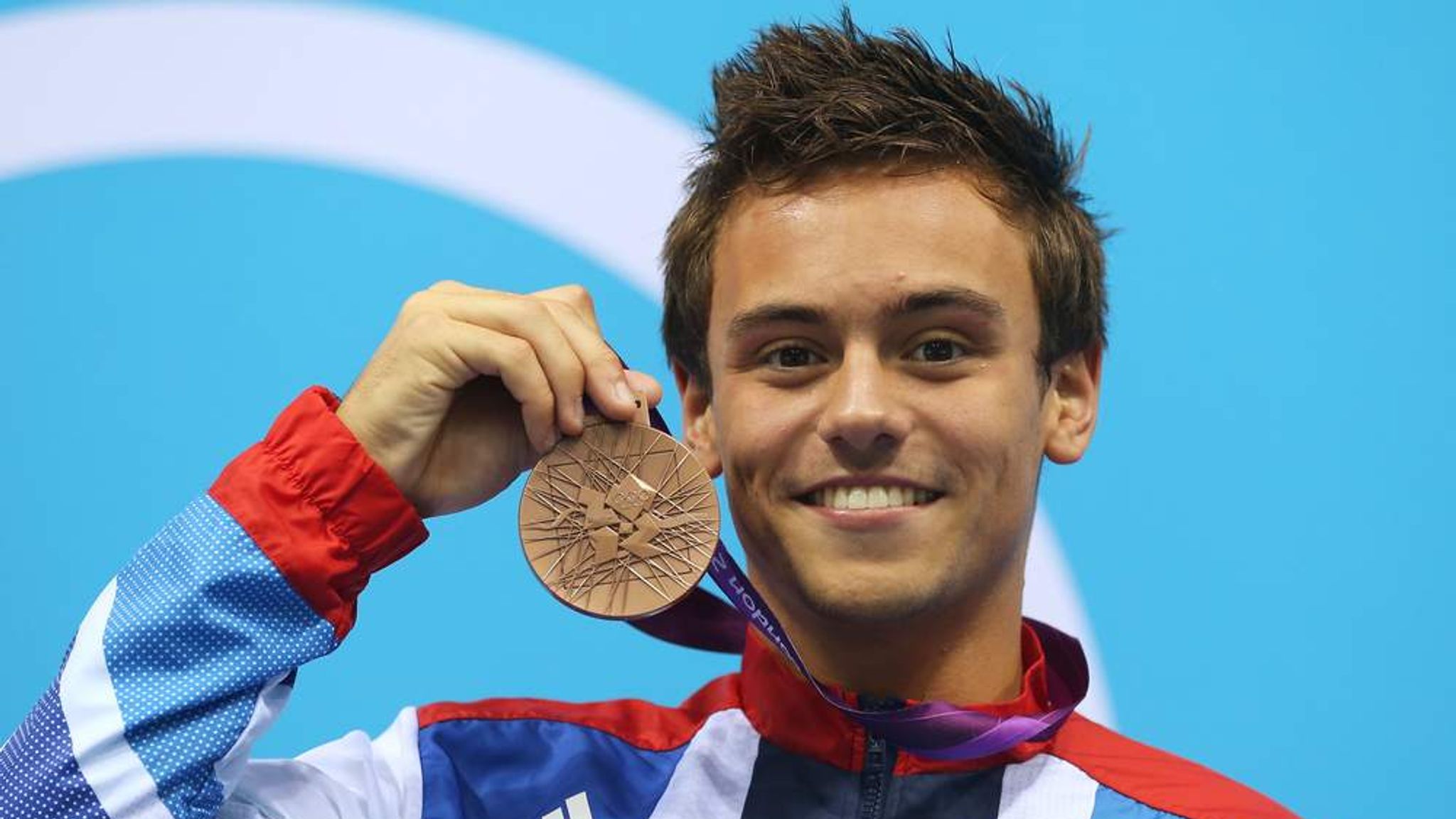 Tom Daley holding his London 2012 bronze medal