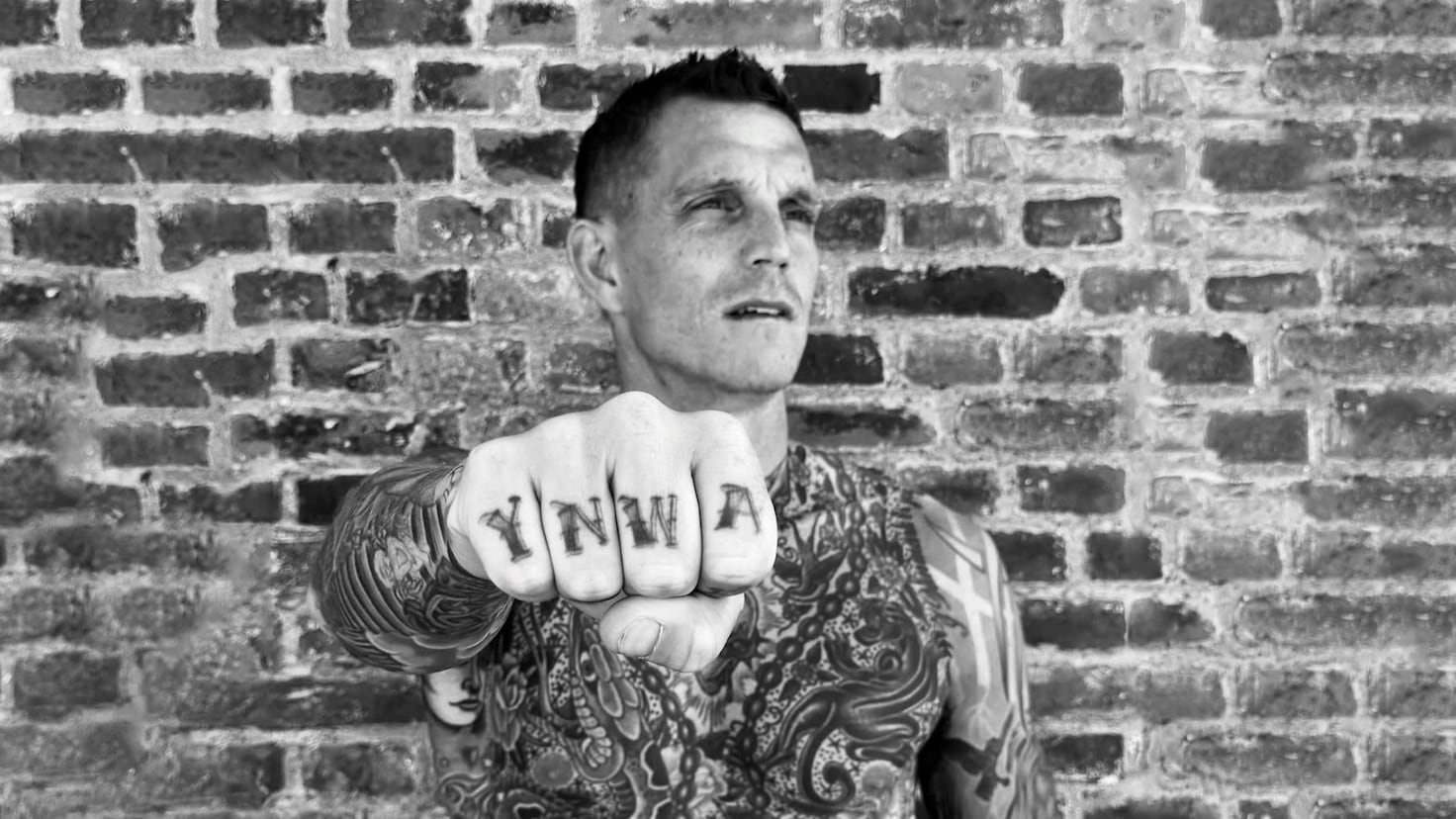 Daniel Agger tattoos: close view of Daniel Agger's YNWA knuckles and layered chest tattoos