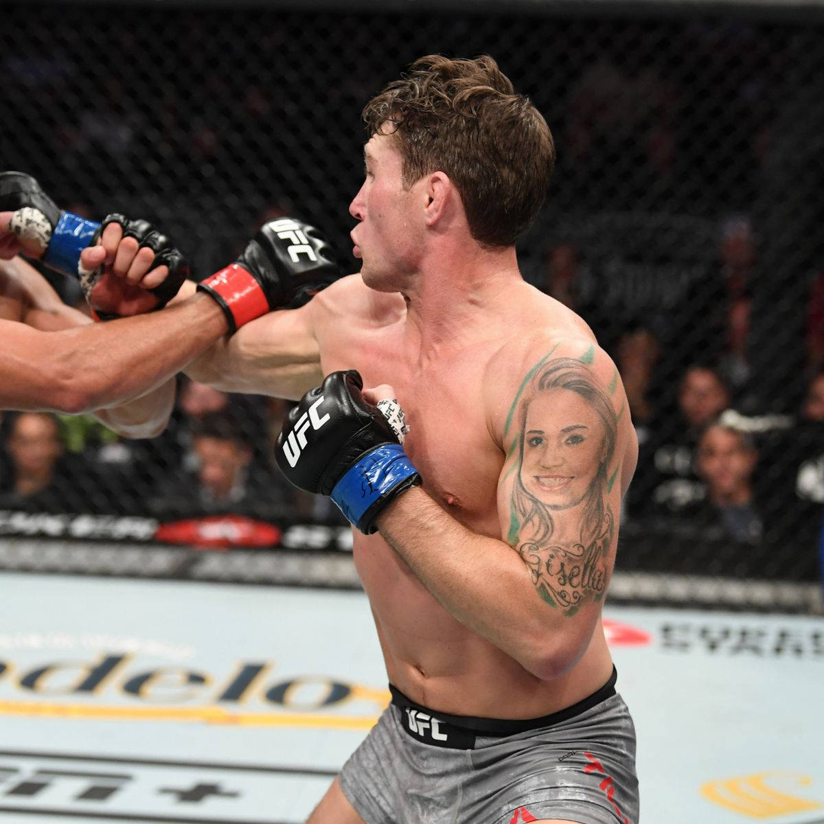 Darren Till showing his arm portrait tattoo during a fight