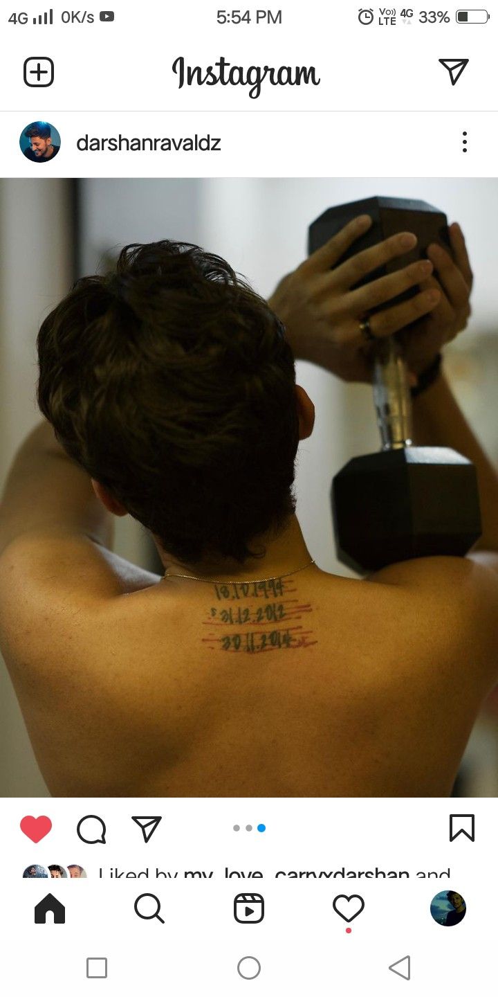 Darshan Raval tattoos: Genuine tattoo photograph showing the dated upper-back design during an exercise pose.