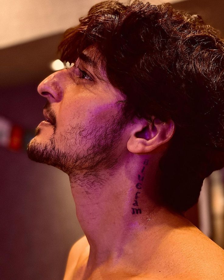 Darshan Raval tattoos: Genuine tattoo photograph showing the vertical neck inscription in a close profile view.