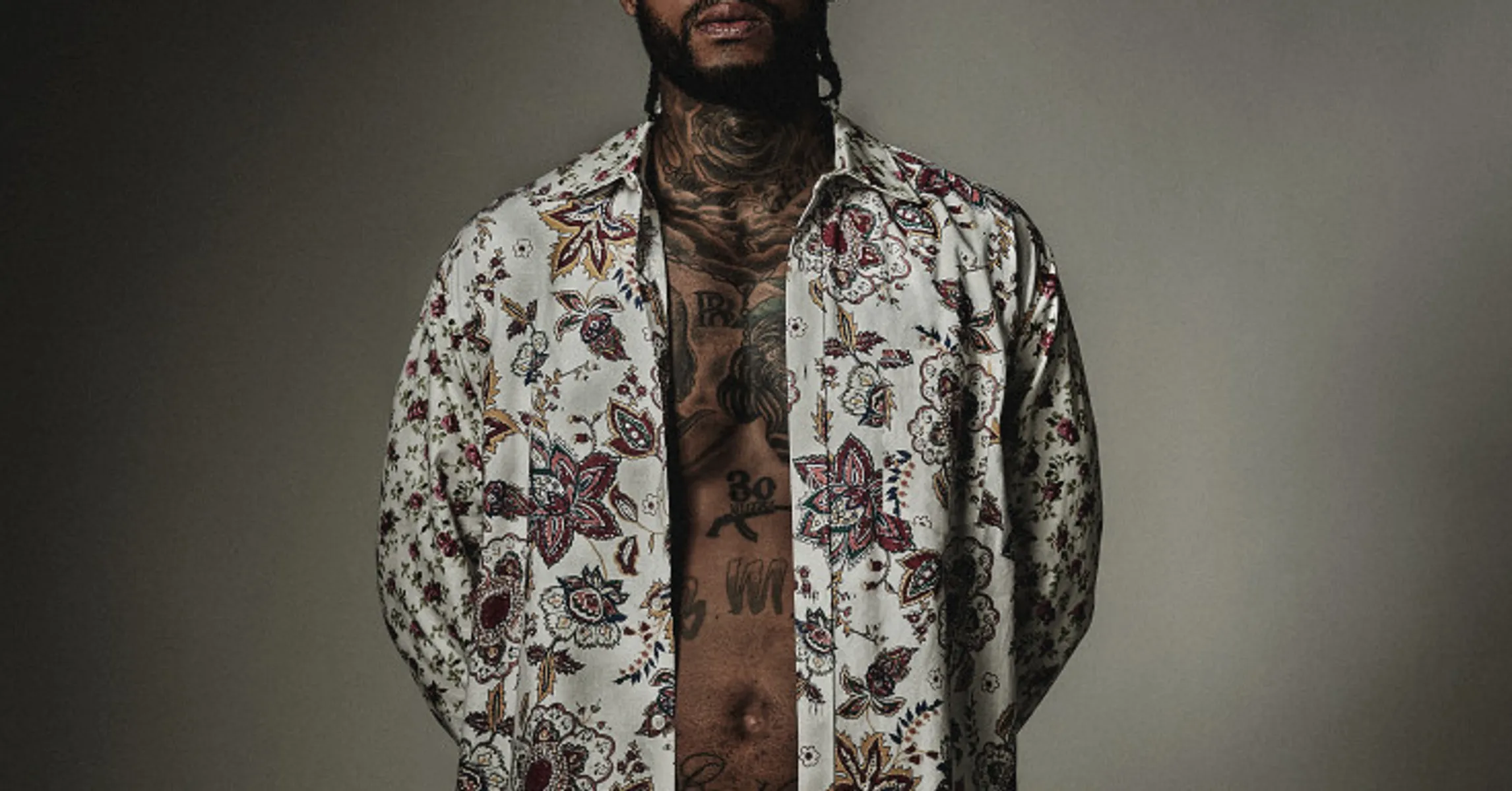 Dave East tattoos: high-resolution open-shirt portrait showing the chest, neck and stomach designs