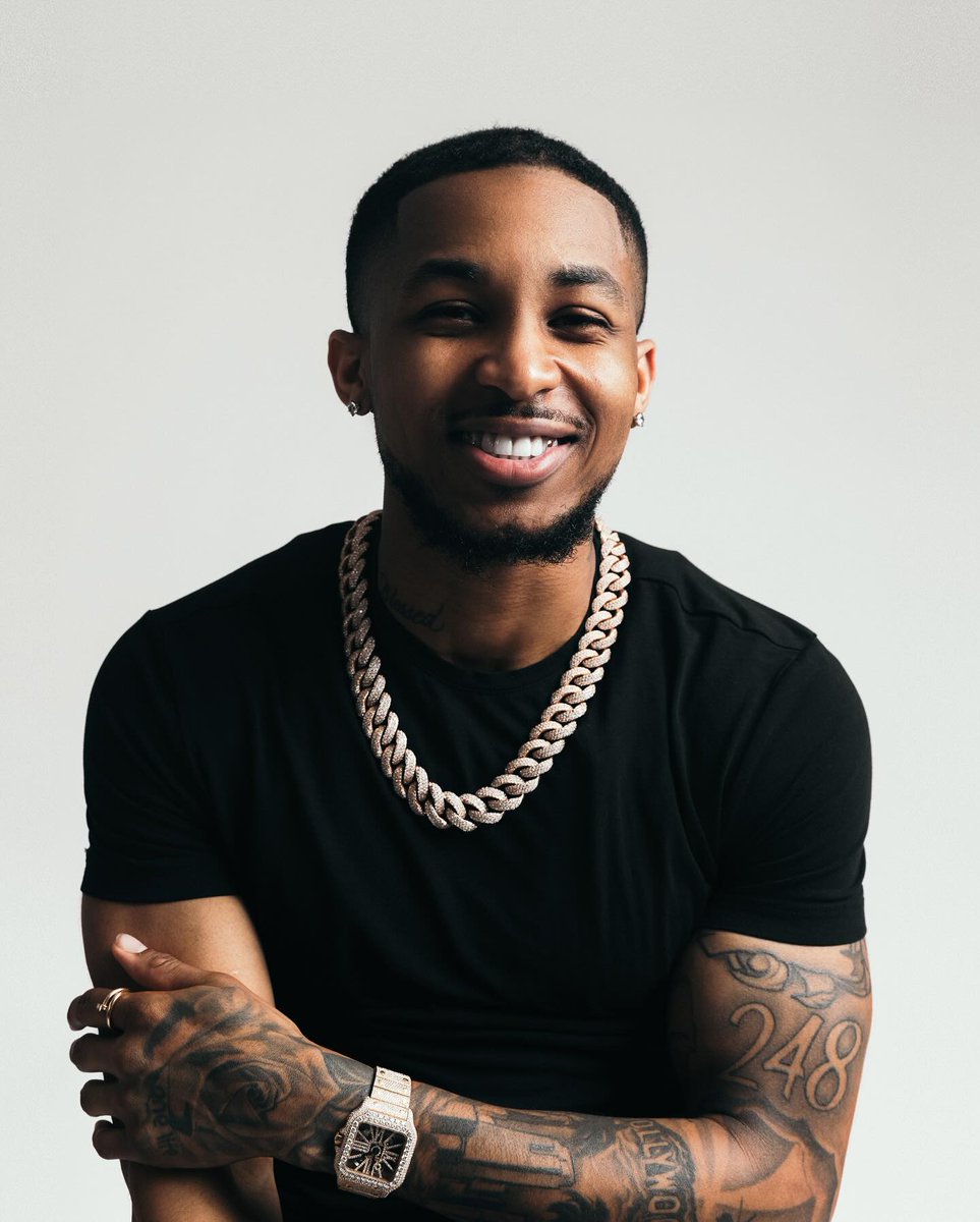 DDG tattoos: the visible forearms and hometown number in a studio portrait