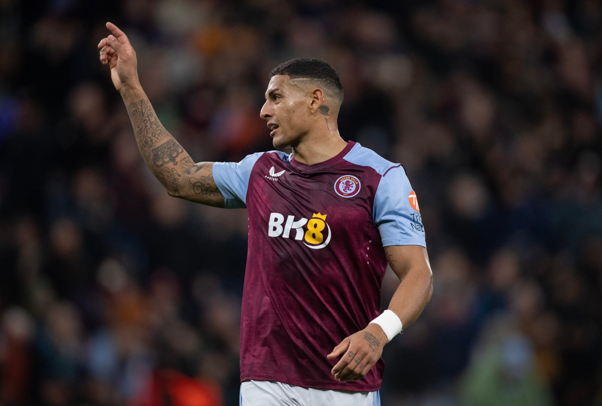 Diego Carlos tattoos: Aston Villa match photograph showing dense lettering, shading and upper-arm coverage