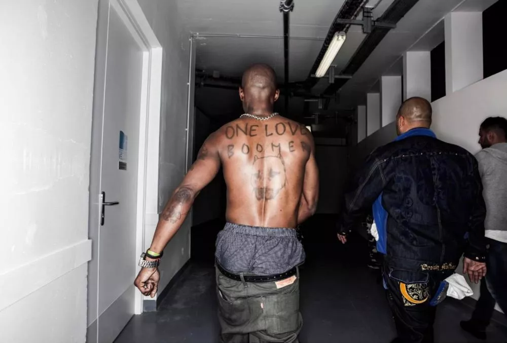 DMX tattoos: shirtless back view showing ONE LOVE BOOMER lettering, dog image and arm ink