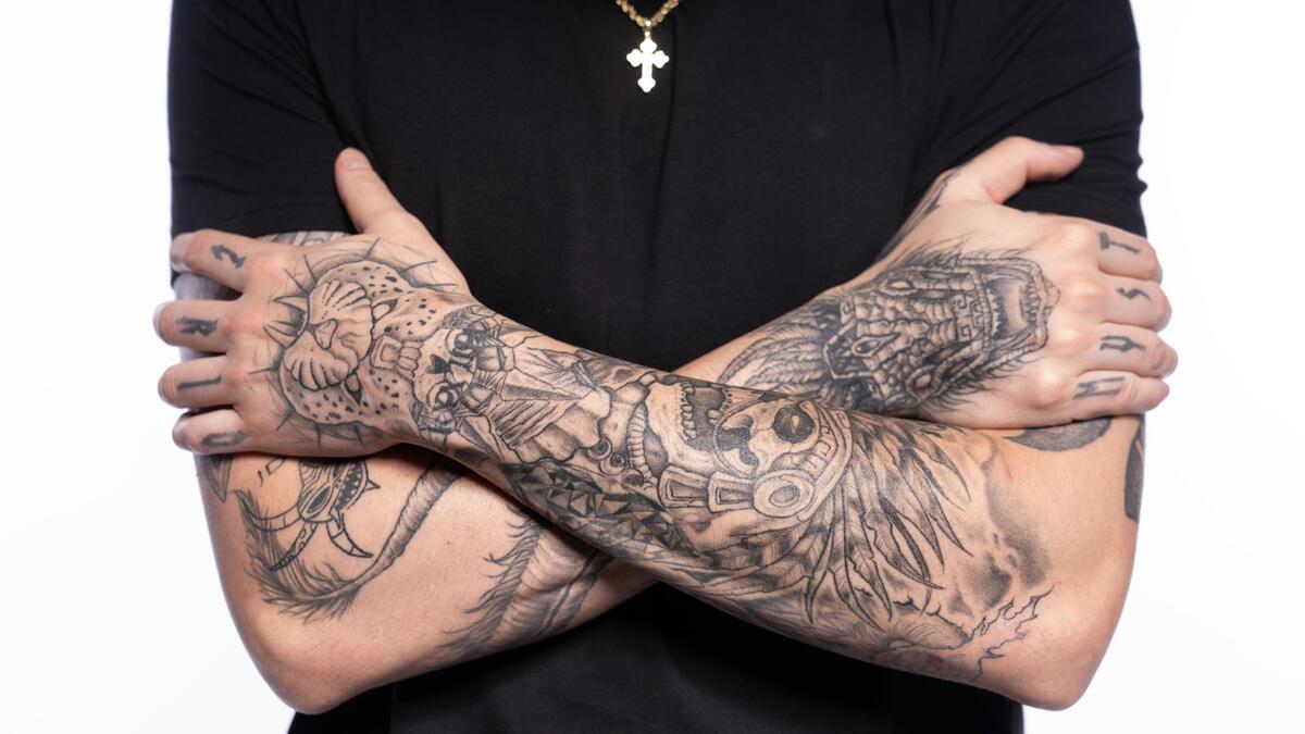 Dominik Mysterio crossed arm tattoos