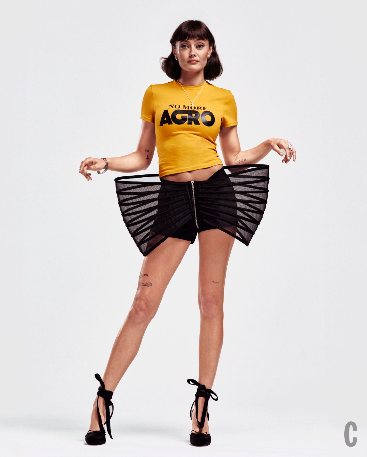 Ella Purnell tattoos: Cosmopolitan UK editorial showing tattoos across both arms and a larger leg figure