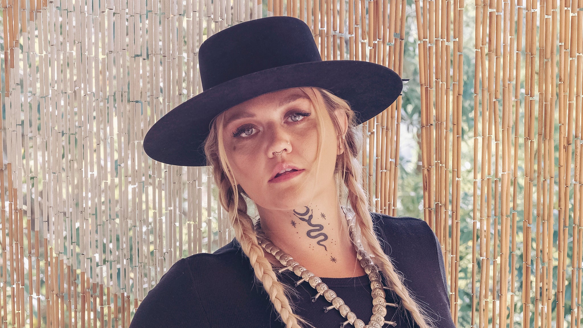 Elle King tattoos: Portrait showing the snake neck tattoo and face-visible styling